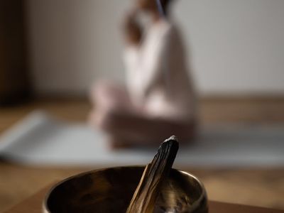 Bowl of water and incense on a yoga shelf.